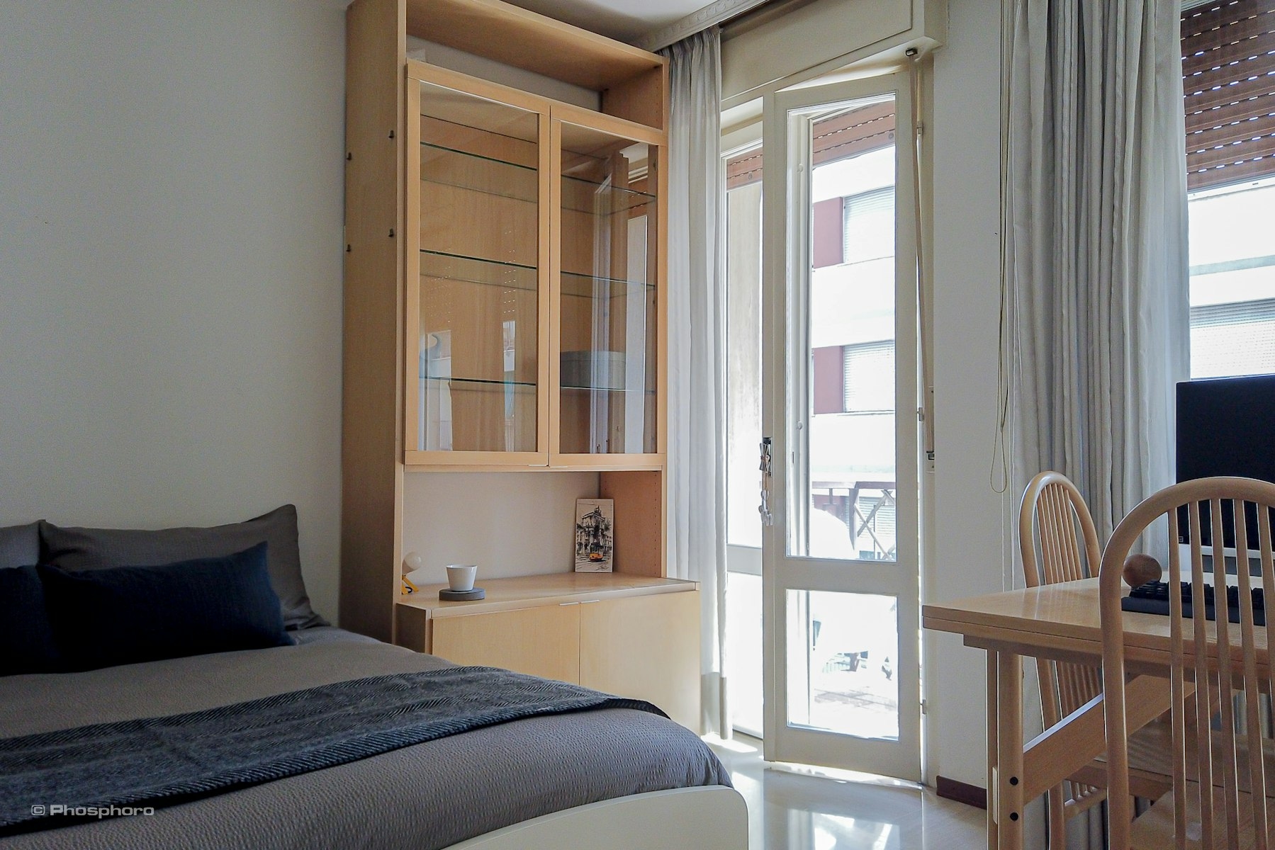 Bed in a spacious double room with private balcony.